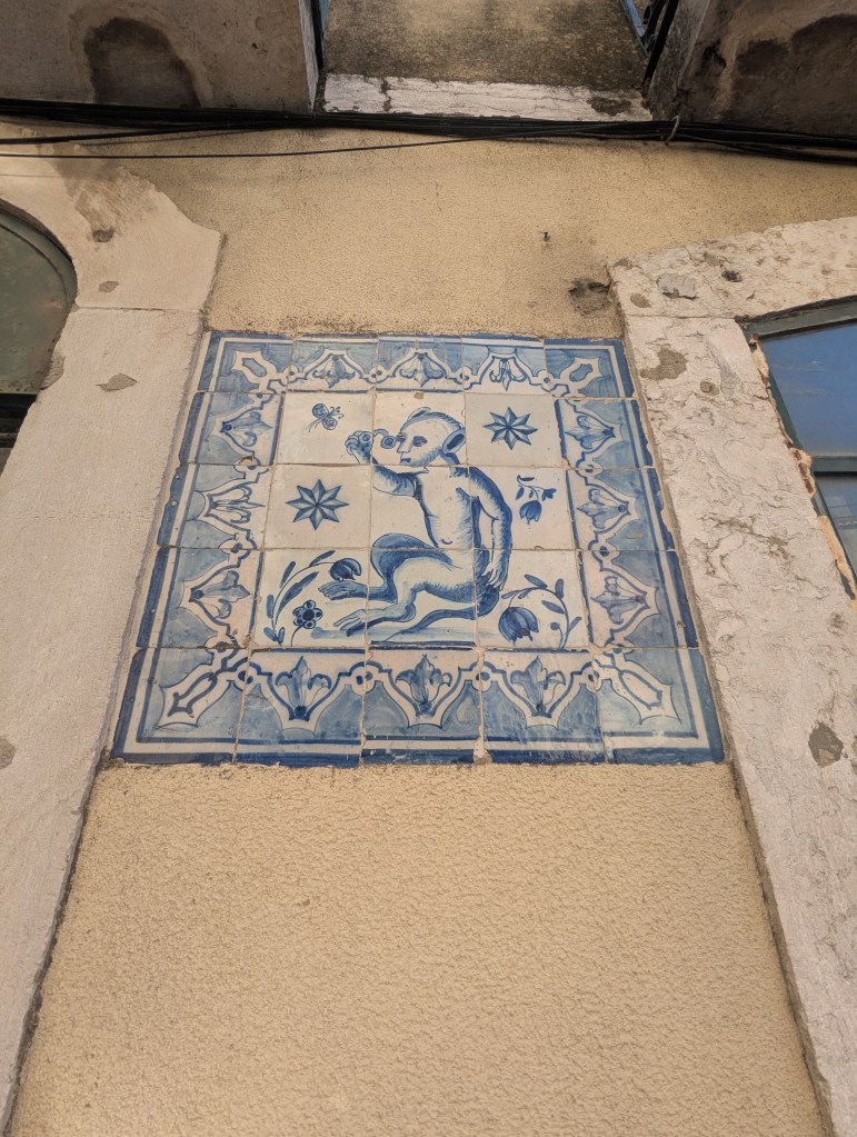 Decorative blue and white tile mural of a child holding a flower, set against a textured wall.